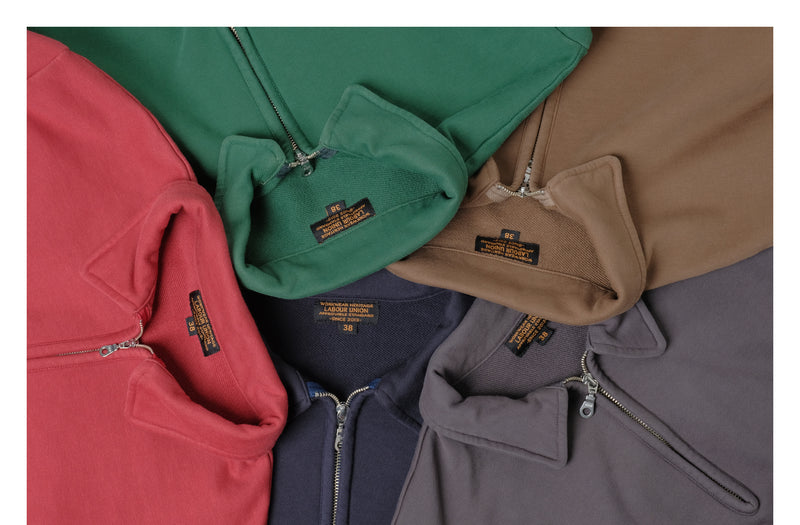 Half-zip collared sweatshirts in red, green, brown, navy and charcoal, folded to show the collars and woven labels