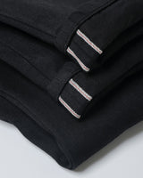 Black Slub Selvedge Straight Jeans in black – close-up of red-line selvedge cuff
